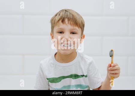 Niedlicher 5-jähriger Junge, der im Badezimmer Zähne mit Bambuszahnbürste putzt. Bild mit selektivem Fokus. Hochwertige Fotos Stockfoto