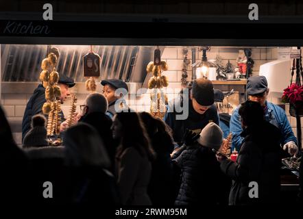 Fastfood in der Winternacht. Viele Leute kaufen nachts an einem Straßenkiosk Essen Stockfoto