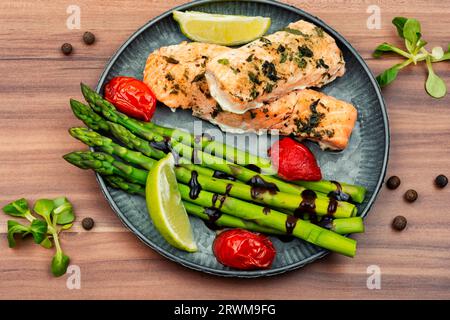 Gegrillte Forelle und grüner Spargel auf einem Holztisch Stockfoto