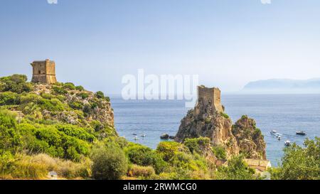 Wachtturm mit Klippen an den felsigen Gipfeln von Faraglioni von Scopello am Meer in der Nähe von Castellammare del Golfo Stadt im Nordwesten Siziliens, Italien, Europa. Stockfoto