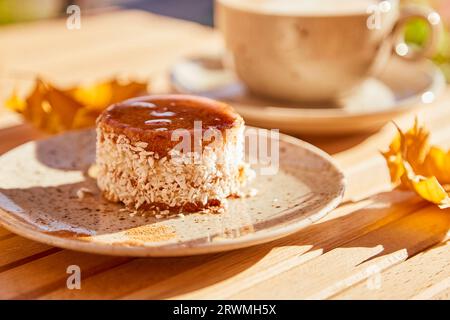 Vegetarischer Karottenkuchen mit Agavensirup. Kein Backen und kein Zuckerdessert mit einer Tasse Kaffee. Gesundes Frühstück draußen. Stockfoto