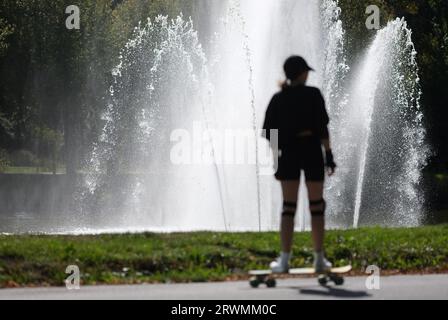 Leipzig, Deutschland. September 2023. Ein Skater fährt an einem Wasserbrunnen im Clara Zetkin Park vorbei. Für das Wochenende erwarten Meteorologen Frühherbstwetter, aber nicht unfreundlich. Quelle: Sebastian Willnow/dpa/Alamy Live News Stockfoto