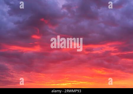 Leuchtender Himmel bei Sonnenuntergang Textur Hintergrund überlagert. Dramatische Wolken in Rot, Orange und Violett. Hochauflösende Fotografie, perfekt für den Austausch des Himmels Stockfoto