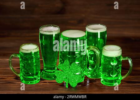 Konzept des St. Patricks-Tages mit Gläsern grünem Bier, Schamrock auf Vintage-Holzhintergrund, Nahaufnahme. Stockfoto