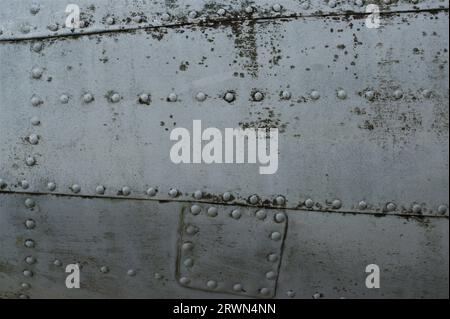 Genieteter Rumpf eines alten Flugzeugs. Antiker metallischer Hintergrund. Stockfoto