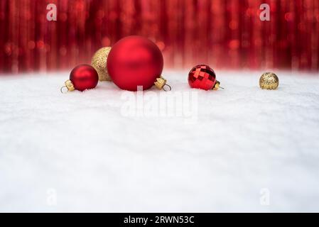 Hintergrund der Weihnachtsfeier mit roten Weihnachtskugeln auf Schnee Stockfoto