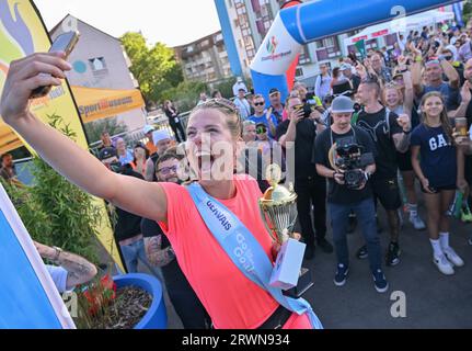 20. September 2023, Brandenburg, Frankfurt (oder): Joyce Hübner, Athletin, wird nach ihrem Abschluss der Tour of Germany von vielen Fans gefeiert. Start und Ziel war die Stadtbrücke in Frankfurt (oder). Joyce Hübner hat nun 120 Marathons hintereinander gelaufen und eine Strecke von 5.200 Kilometern entlang der deutschen Grenze zurückgelegt. Mit diesem Projekt möchte der Extremsportler andere Menschen dazu inspirieren, ihre Komfortzone zu verlassen und zu zeigen, wie das Testen Ihrer persönlichen Grenzen nachhaltig positive Auswirkungen auf Sie haben kann. Foto: Patrick Pleul/dpa Stockfoto