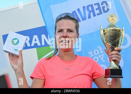 20. September 2023, Brandenburg, Frankfurt (oder): Joyce Hübner, Athletin, hält nach ihrem Abschluss der Tour of Germany ein Geschenk und einen Pokal der Stadt Frankfurt (oder). Start und Ziel war die Stadtbrücke in Frankfurt (oder). Joyce Hübner hat nun 120 Marathons hintereinander gelaufen und eine Strecke von 5.200 Kilometern entlang der deutschen Grenze zurückgelegt. Mit diesem Projekt möchte der Extremsportler andere Menschen dazu inspirieren, ihre Komfortzone zu verlassen und zu zeigen, wie das Testen Ihrer persönlichen Grenzen nachhaltig positive Auswirkungen auf Sie haben kann. Foto: Patrick Pleul/dpa Stockfoto