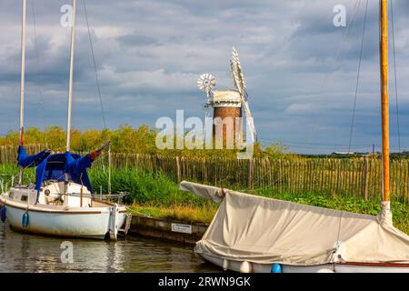 Boote legten in der Nähe der Horsey Windpumpe bei Horsey in den Norfolk Broads England an, gebaut 1912 und bis 1943 in Betrieb. Stockfoto