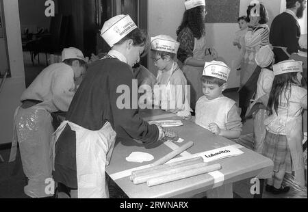 Jüdische Kinder aus den hebräischen Gemeinden Birmingham und Solihull, die im März 1991 an einer Matzo-Bäckerei vor dem PASSOVER im Lubavitch Centre in der Willows Road Birmingham teilnahmen. Den Kindern die Regeln des Backens des ungesäuerten Brotes beibringen Rabbiner Herchel Rader, Minister der Solihull-Synagoge und Professor Sam Aburdaram, Leiter der Solihull-Cheder-Schule Stockfoto