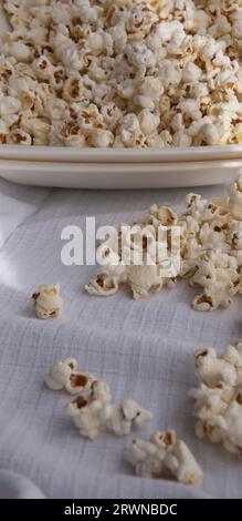 Verstreutes weißes selbstgemachtes Popcorn in einer weißen Schüssel, weißer Hintergrund, nahe up.freshly Popcorn Stockfoto