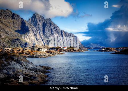 Häuser von Henningsvaer auf dem niedrigen Küstenfelsen auf der Insel Heimoya, Lofoten-Inseln, Norwegen. Stockfoto