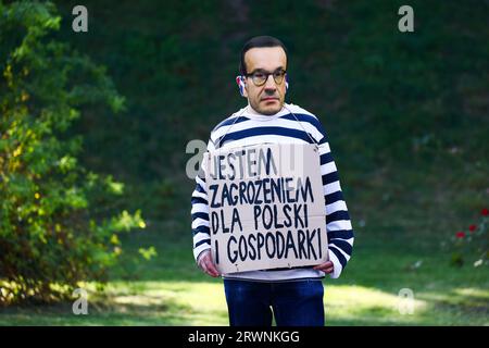 Krakau, Polen. September 2023. Ein Demonstrant trägt eine Maske mit dem Gesicht von Ministerpräsident Mateusz Morawicki und hält ein Banner mit der Aufschrift "Ich bin eine Bedrohung für Polen und die Wirtschaft" während eines regierungsfeindlichen Protestes in Krakau, Polen, am 18. September 2023. Die Demonstranten organisierten eine Kundgebung gegen die Politiker der regierenden Partei PiS (Recht und Gerechtigkeit), einschließlich des Parteiführers Jaroslaw Kaczynski, der auf der Burg Wawel ankam. Die angespannte politische Atmosphäre im Land entsteht durch die bevorstehenden Parlamentswahlen am 15. Oktober. (Bild: © Beata Zawrzel/ZUMA Press Wire) EDITORI Stockfoto