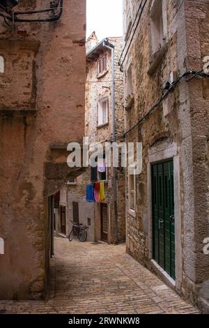 Eine ruhige Straße im historischen Zentrum der mittelalterlichen Küstenstadt Rovinj, Istrien, Kroatien. Die Gebäudefront links hat einen Jet-Ting mit Bogenstütze Stockfoto