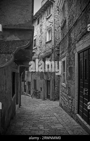 Eine ruhige Straße im historischen Zentrum der mittelalterlichen Küstenstadt Rovinj, Istrien, Kroatien. Die Gebäudefront links hat einen Jet-Ting mit Bogenstütze Stockfoto