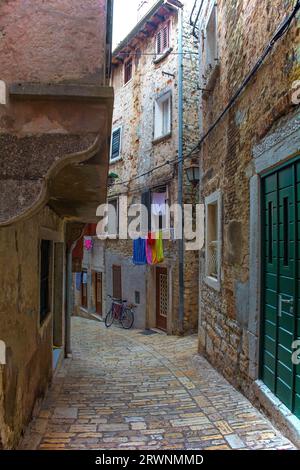 Eine ruhige Straße im historischen Zentrum der mittelalterlichen Küstenstadt Rovinj, Istrien, Kroatien. Die Gebäudefront links hat einen Jet-Ting mit Bogenstütze Stockfoto