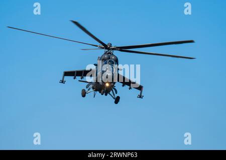 Sowjetischer, schwarzer Mi-24-Militärhubschrauber, der am Himmel fliegt Stockfoto