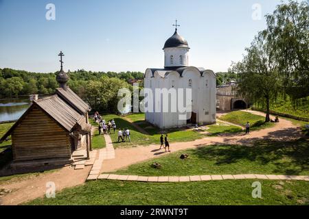 Staraya Ladoga, Russland - 25. Mai 2023: Eine Gruppe von Touristen auf dem Territorium der Festung Staraya Ladoga. Weiße Steinkirche St. Georg der 12 Stockfoto