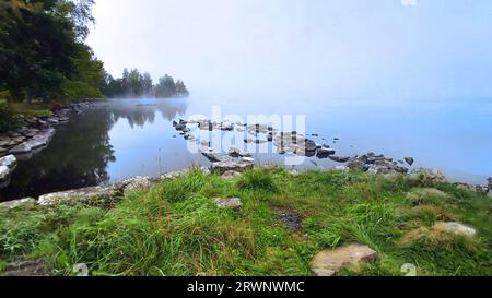 Wenn der Morgennebel versucht, sich vom See zu heben und die Sonne auszulassen. Stockfoto