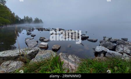 Wenn der Morgennebel versucht, sich vom See zu heben und die Sonne auszulassen. Stockfoto