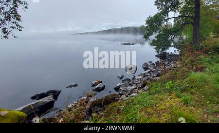 Wenn der Morgennebel versucht, sich vom See zu heben und die Sonne auszulassen. Stockfoto