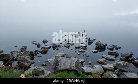 Wenn der Morgennebel versucht, sich vom See zu heben und die Sonne auszulassen. Stockfoto