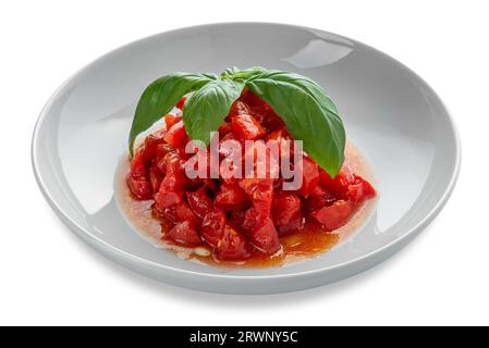 Salat aus gehackten und gewürfelten rohen Tomaten, mit Olivenöl und Basilikumblättern in weißem Gericht isoliert auf weißem Clippingh-Pfad im Preis inbegriffen Stockfoto