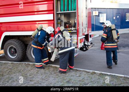 Gruppe von Feuerwehrleuten auf Gasmasken und Vorbereitung auf die Feuer löschen. Stockfoto