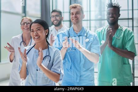 Professionelle multinationale Ärzte applaudieren vor der Kamera. Diagnosediskussion Stockfoto