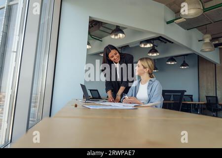 Zwei Kollegen besprechen das Projekt, bevor sie dem Teamleiter im Büro eine Präsentation zeigen Stockfoto