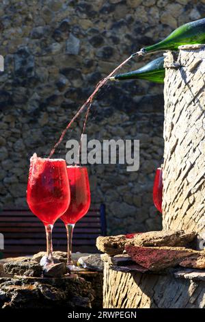 Weinflaschen mit Rotwein in Weingläsern am Brunnen des Weinguts Milestii Mici in Milestii Mici, Moldawien Stockfoto