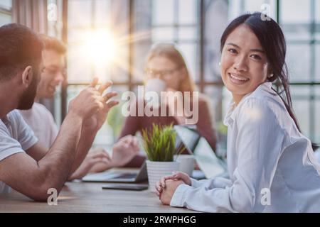 Multiethnische Geschäftspartner treffen sich mit Laptops am Tisch im modernen Büro Stockfoto
