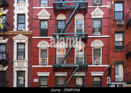USA, New York City, Fassade von Stadthäusern aus dem späten 19. Frühen 20. Jahrhundert in Nolita/Little Italy in Lower Manhattan; Feuerlöscher und Fenster Stockfoto