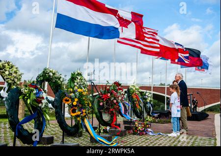 Man sieht Menschen, die Blumenkränze am Denkmal hinterlassen. Am Waal Crossing Memorial (Waaloversteek-Denkmal) fand eine feierliche Zeremonie statt, um der heldenhaften Überquerung des Waal River durch amerikanische Soldaten der 82. Airborne Division während der Operation zu gedenken, die heute 78 Jahre zurückliegt. Die Zeremonie wurde mit der Anwesenheit des Bürgermeisters von Nijmegen, Hubert Bruls, und der Fallschirmjäger der 82. Airborne Division aus den USA gefeiert. Obwohl Operation Market Garden erfolglos blieb, konnten die Amerikaner und Briten Nijmegen, die älteste Stadt der Niederlande, nach heftigen Kämpfen befreien. Stockfoto