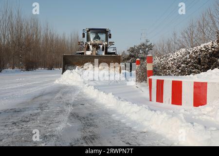 LUANNAN COUNTY, China - 14. Februar 2022: highway Traffic Manager fahren Gabelstapler, um den Schnee auf der Autobahn zu räumen und sicherzustellen, dass die Autobahn frei ist Stockfoto