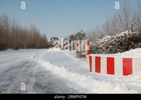 LUANNAN COUNTY, China - 14. Februar 2022: highway Traffic Manager fahren Gabelstapler, um den Schnee auf der Autobahn zu räumen und sicherzustellen, dass die Autobahn frei ist Stockfoto