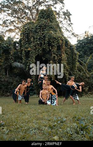 Indonesische Tänzerinnen posieren mit ihren Körpern, während sie vor dem Wald ein traditionelles goldenes Kostüm von Javanern tragen Stockfoto