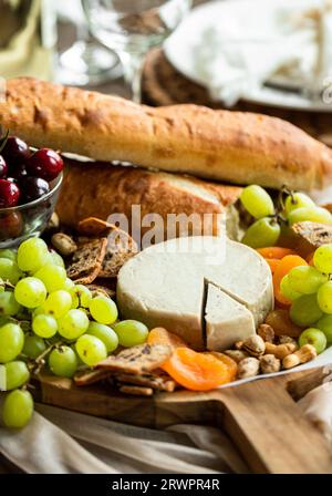 Käsebrett mit Trauben und Brot Stockfoto