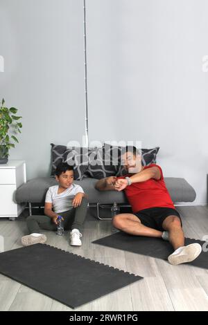 Übergewichtiger Latino Vater und Sohn feiern Rekord für Zeit Sport zu Hause, um ihre Gesundheit zu verbessern Stockfoto