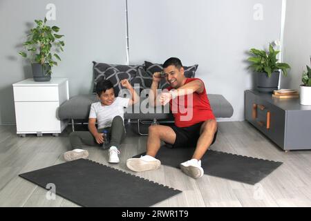 Übergewichtiger Latino Vater und Sohn feiern Rekord für Zeit Sport zu Hause, um ihre Gesundheit zu verbessern Stockfoto