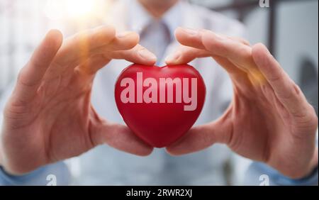 Liebe-Konzept. ein rotes Herz hält in Händen. Stockfoto