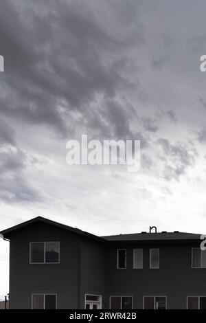 Wolken bewegen sich über ein graues Haus Stockfoto