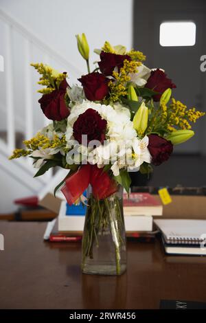 Blumenstrauß in einer Vase auf dem Tisch mit Büchern Stockfoto