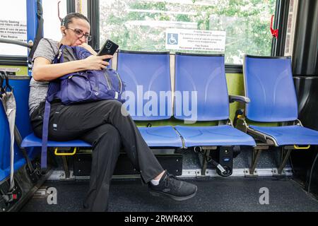 Miami Beach Florida, Miami-Dade Metrobus, öffentliche Verkehrsmittel, an Bord, Blick auf das Lesen Smartphone, Frau Frau Dame, Erwachsener, Resident Passeng Stockfoto