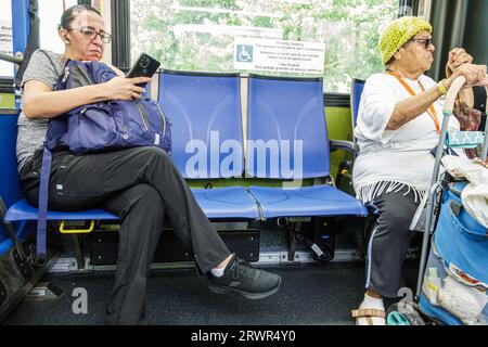 Miami Beach Florida, Miami-Dade Metrobus, öffentliche Verkehrsmittel, an Bord, Blick auf das Lesen von Smartphone, Frau Frau, Frau, Frau, Erwachsene, Resident Stockfoto