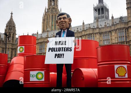 London, Großbritannien. September 2023. Ein Oxfam-Demonstrant, der als Rishi Sunak verkleidet ist, wird vor dem Parlament gesehen. Oxfams Kampagne „Make Polluters Pay“ ruft große Öl- und Gasunternehmen wie BP und Shell dazu auf, mehr Steuern zu zahlen, um bei der Beschaffung von Mitteln für vom Klimawandel verwüstete Gemeinden zu helfen. Quelle: SOPA Images Limited/Alamy Live News Stockfoto