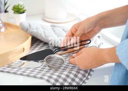 Frau mit Spatel und Sieb in der Küche Stockfoto