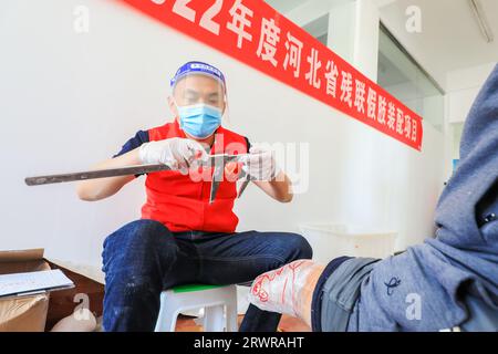 LUANNAN COUNTY, China - 13. Mai 2022: Mitarbeiter, die künstliche Gliedmaßen für Behinderte installieren, Nordchina Stockfoto