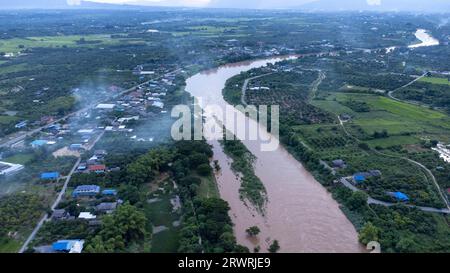 Luftaufnahme des Ping River über Reisfelder und ländliche Dörfer bei Sonnenuntergang. Blick auf die Dörfer von Chiang Mai und den Fluss Ping von einer Drohne aus. Stockfoto