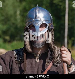 SHEVELEVO, RUSSLAND - 05. AUGUST 2023: Porträt eines frühmittelalterlichen Kriegers in einem Helm. Historisches Festival „Princely Brotherhood“ Stockfoto